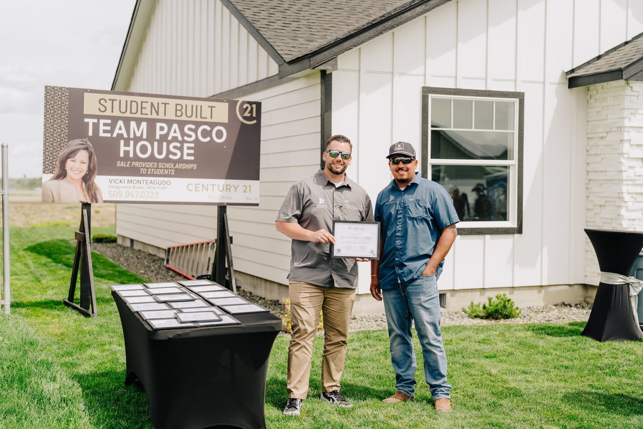Eminent Roofing team with a Tri-Cities homeowner in front of a completed project