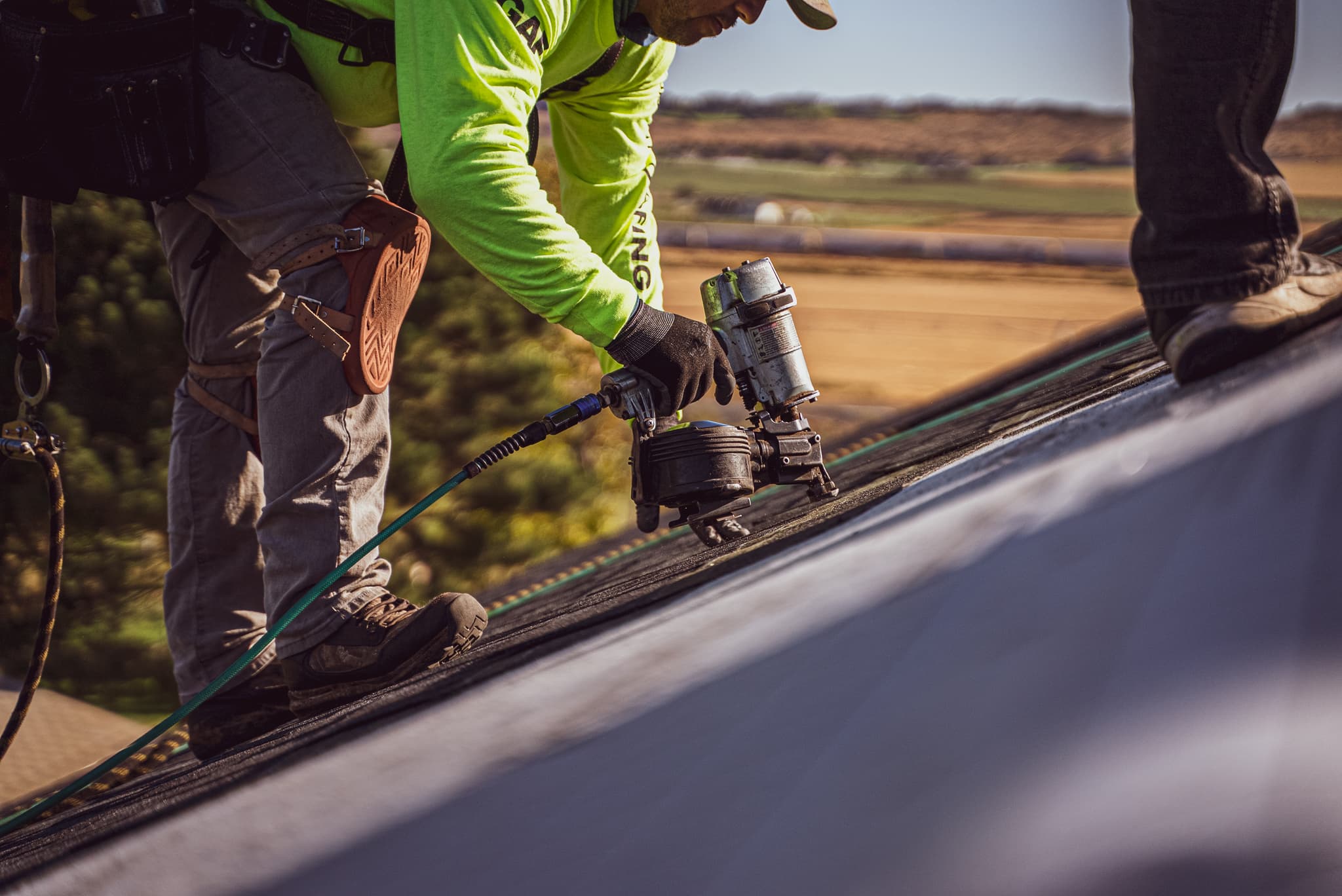 Roofer fastening shingles on a steep-slope roof during an Eminent Roofing install