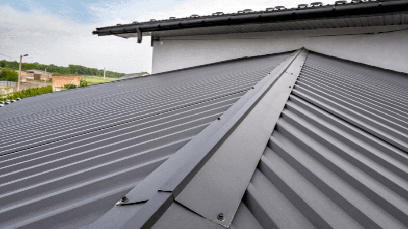 Dark charcoal exposed-fastener metal roof with ridge detail