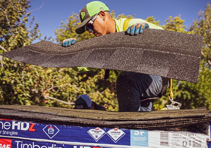 man picking up shingles from package